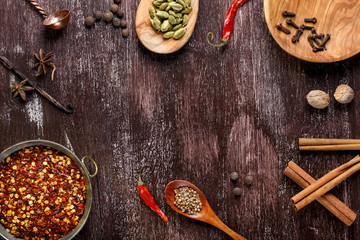 Various spices on dark brown background.