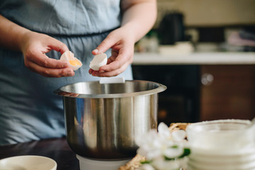 cooking woman breake egg above the bowl