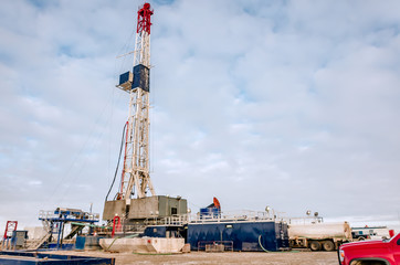 Drilling an oil well in a field with a blue sky