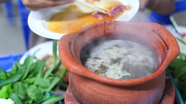 Girl fill Pork and Meat in Clay Pot to make Thai Hot Pot Street Food (Jim Jum), Thai Food