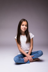 lovely little girl sitting on the floor on white background