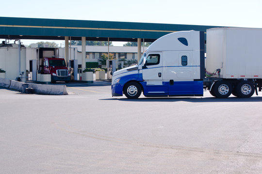 Big rig semi truck with dry van trailer on truck stop with gas station
