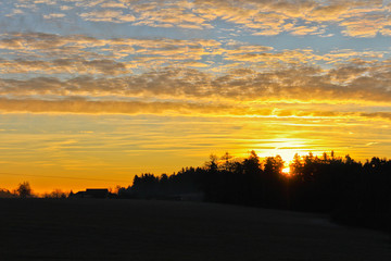 Famous gold winter sunrise on Czech countryside with dark landscape silhouette, close up photo