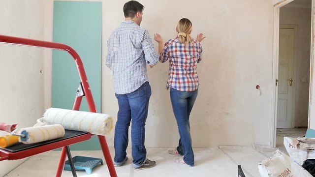 Slow motion footage of young couple shouting at each other at apartment under renovation