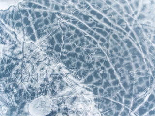Flight over frozen lake breaking ice in rural village, Lithuania. Aerial photography during winter...