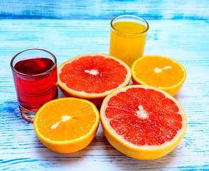 citrus fruits and fresh juice on a light wooden background 