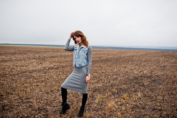 Portrait of brunette curly girl in jeans jacket at field.