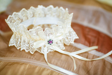 Decorated wedding garter on sofa. Marriage concept