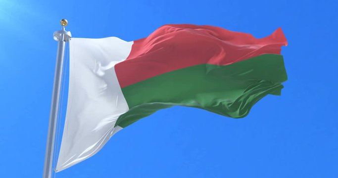 Madagascar flag waving at wind in slow in blue sky, loop