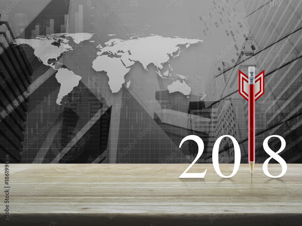 Poster red pencil in the shape of a dart with 2018 white text on wooden table over world map with financial