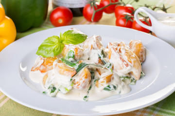 close up of potatoes with white sauce and onions