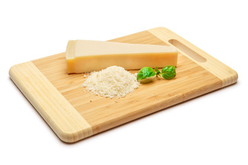 a piece of Parmesan and grated cheese on cutting board white background