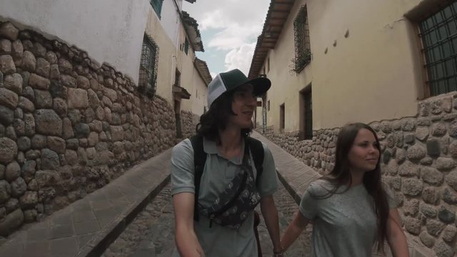 Young couple walking in the old city.Tourist couple filming themselves on go pro.A loving couple is walking along the old streets of the city,couple taking selfie.