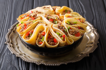 Fototapeta premium Homemade crepes stuffed with beef, peppers and onions closeup. horizontal