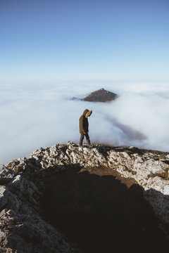Man on rocky cliff in clouds