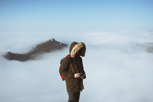 Man on rocky cliff in clouds