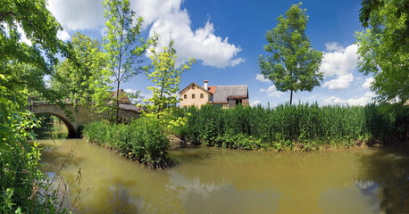Bauernhaus mit Brücke am Fluss