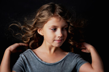 kinky girl with long hair. In the Studio on a black background. A fairy tale for children. Lives in the frame