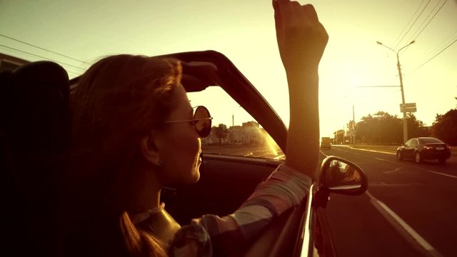 Dream. Beautiful girl have fun riding in a red convertible cabriolet car, freedom concept.