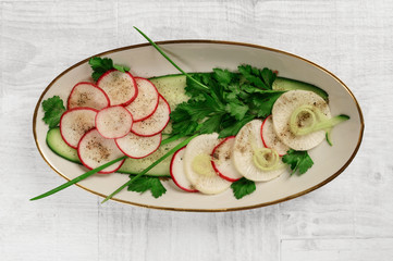 radish salad with greens on a platter. the view from the top