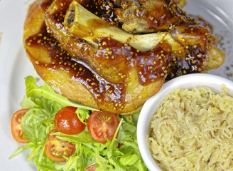 Pork knuckle with garnish on a white plate