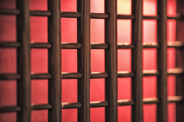Window or door lattices, wooden with red light and carpet and the background.