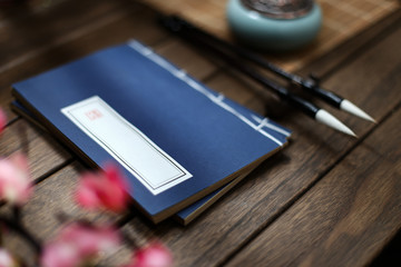 chinese vintage old book,incense burner and brush on wooden table