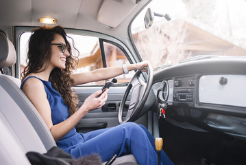 Naklejka premium Beautiful young woman using her mobile phone in the car.