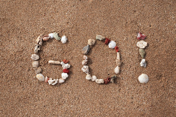 Text Go on sandy beach made from shells. Concept of travel and active lifestyle