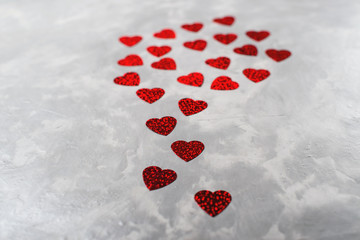 A lot of red paper hearts on grey concrete background. Valentine's Day card.