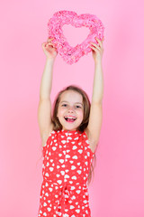Kid smile with raised hands on pink background