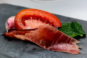 Pizarra, hierbabuena, jamón tomate y ajo