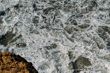 Sea water surface with white foam and waves pattern