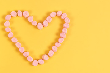 marshmallow sweets placed in heart shape.valentine's day and love concept on yellow background