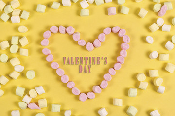 Text valentine's day in the Heart shape from sweets. love concept on yellow background