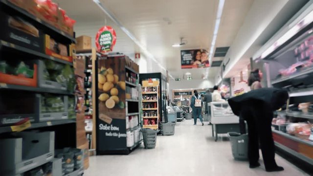 People Shopping In Grocery Store, Shopping Cart Slow Motion. Slow motion of a shopping cart in the supermarket with people