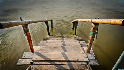 Small Wooden Plank Staircase with Bamboo Handrail to the Sea