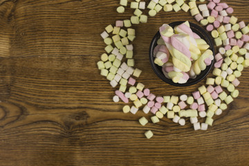 marshmallow Candies placed in a basket around the other candies.valentine's day and love concept on wooden background
