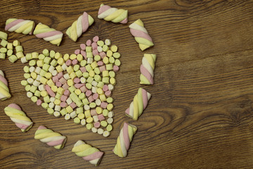 Candies placed in heart shape.valentine's day and love concept on wooden background