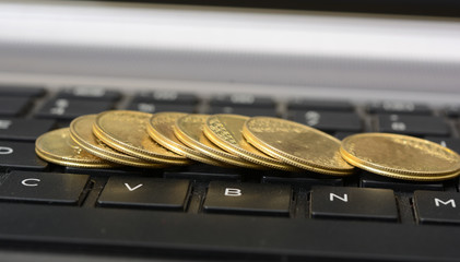 Coins laying on laptop keyboard closeup