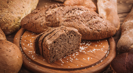 Various baked breads and rolls on rustic wooden table