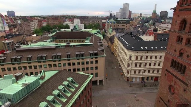 Aerial shot flying over city street in Malmö, Sweden. Church and buildings