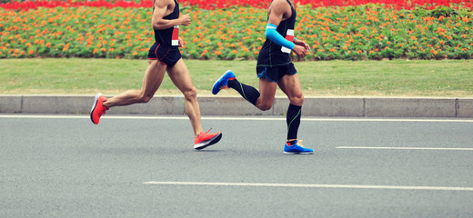 marathon runners legs running on city road