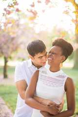 Fototapeta premium Portrait of the young happy couple who standing in embrace in the park and smiling