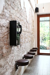 ancient vintage telephone hanging on bricks wall