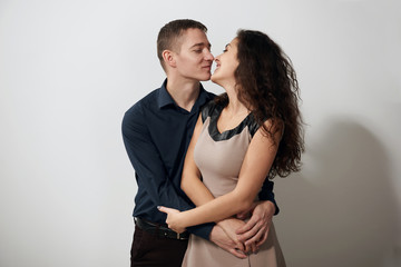 Portrait of young couple posing on white background, love concept