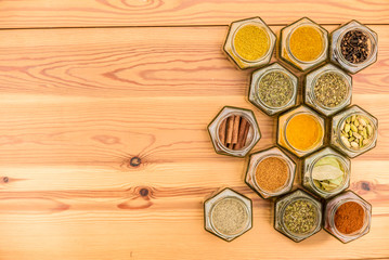 Herbs and spices with space for text on wooden background.