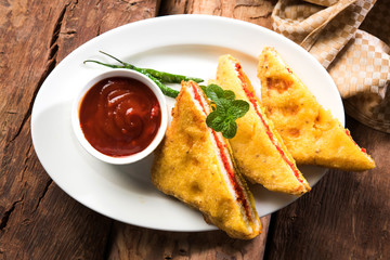 Bread Pakora or Bread Pakoda or bhaji served along with Green Chutney and tomato ketchup. selective focus   © StockImageFactory