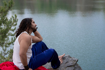 Young Man sitting alone outdoor Travel Lifestyle concept with lake.