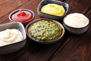 Set of sauces - ketchup, mayonnaise, mustard bbq sauce, pesto, mustard on wooden table